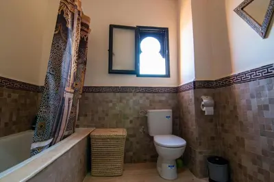 a bathroom with a toilet and a tub and a window at Villa Familiale, Piscine et jardin privés, proche du centre ville in Marrakech