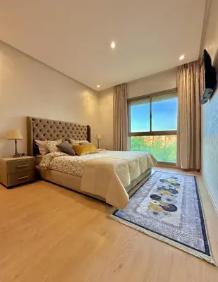a bedroom with a bed and a large window at Luxury Apartments in Marrakech