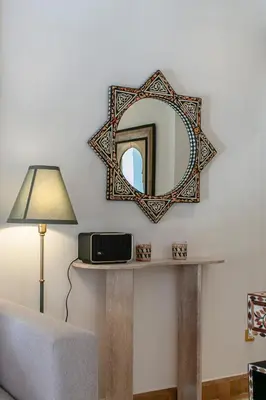 a mirror on a wall next to a table with a lamp at Marrakech Palmeraie 3, 2-bedroom appartement, ,res with pool in Marrakech