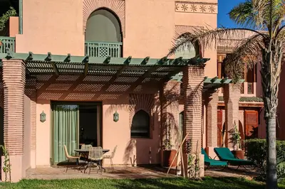 a house with a patio with a table and chairs at Marrakech Palmeraie 3, 2-bedroom appartement, ,res with pool in Marrakech