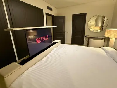 a bedroom with a white bed with a television on it at Modern apartment in Gueliz Plaza in Marrakech