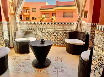 a balcony with chairs and tables and a building at Moroccan style Soltana pool & central internet in Marrakech