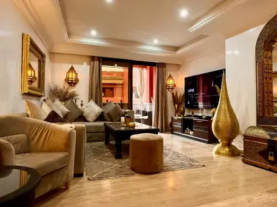 a living room with a couch and a tv at Moroccan style Soltana pool & central internet in Marrakech