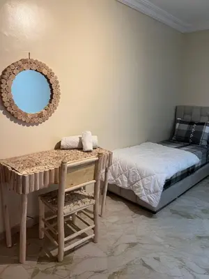 a bedroom with a bed and a table and a mirror at Apartment in Gueliz in Marrakech