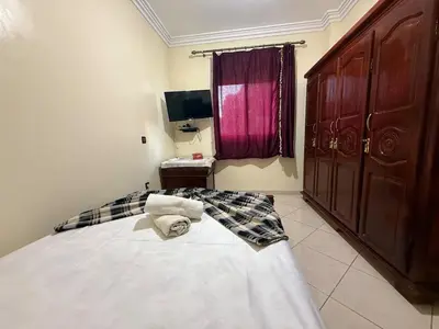a bedroom with a large white bed and a window at Calm & Comfortable Appartement Close to Airport in Marrakech