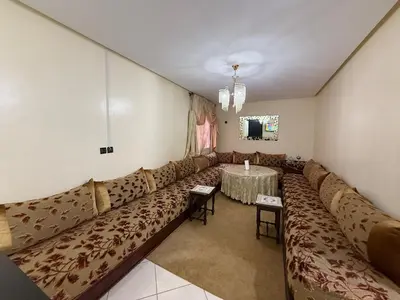 a living room with a long couch and a table at Calm & Comfortable Appartement Close to Airport in Marrakech