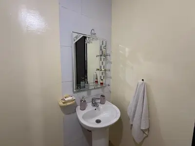 a white bathroom with a sink and a mirror at Calm & Comfortable Appartement Close to Airport in Marrakech