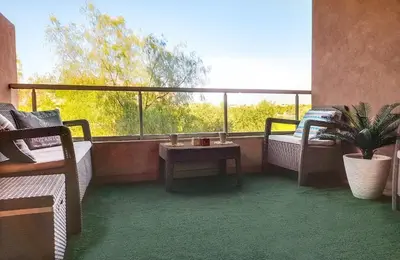 a balcony with a table and chairs and a window at Luxury Apartments in Marrakech