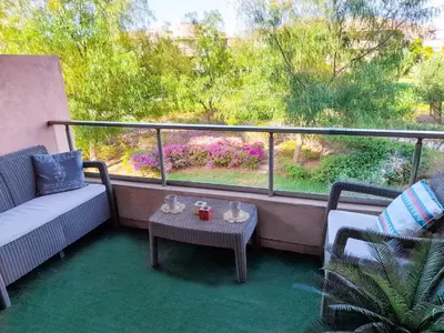 a balcony with a couch and a table and a window at Luxury Apartments in Marrakech