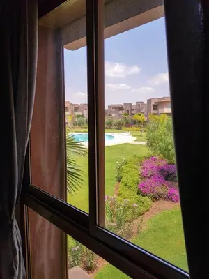 a window with a view of a garden and a pool at Luxury Apartments in Marrakech