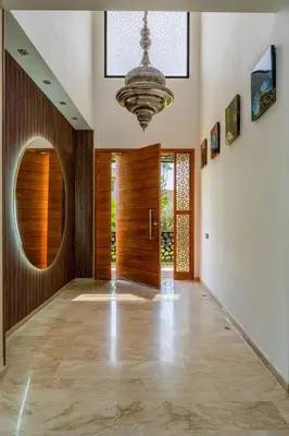 a hallway with a wooden door and a chandelier at Golf Resort 4BR Villa Heated Pool Free Pickup in Marrakech