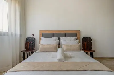a bedroom with a large white bed with two chairs at Golf Resort 4BR Villa Heated Pool Free Pickup in Marrakech
