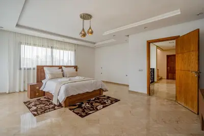 a bedroom with a large bed and a hallway at Golf Resort 4BR Villa Heated Pool Free Pickup in Marrakech