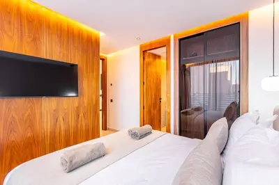 a bedroom with a large white bed with a flat screen tv at New apartment, quiet and well located with balcony in Marrakech
