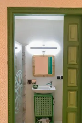 a bathroom with a sink and a green door at Riad Dar 77 in der Medina mit Terrasse in Marrakech