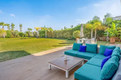 a living room with a blue couch and a table at Modern Golf Retreat Heated Pool & Free breakfast in Marrakech