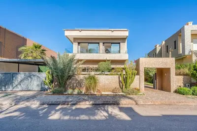 a house with palm trees in front of it at Modern Golf Retreat Heated Pool & Free breakfast in Marrakech