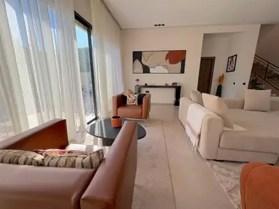 a living room with white furniture and a large window at Palais Naya in Marrakech