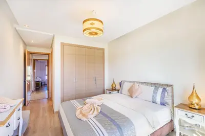 a bedroom with a large bed and a bathroom at Golf View Escape in Oulad Akkou