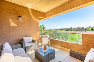 a living room with a couch and chairs and a large window at Golf View Escape in Oulad Akkou