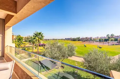 a balcony with a view of a golf course at Golf View Escape in Oulad Akkou