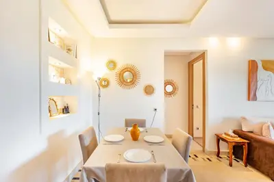 a dining room with a table and a couch at Golf View Escape in Oulad Akkou