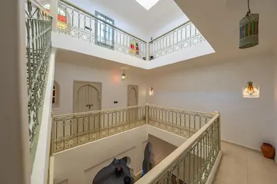 a staircase in a house with a cat sitting on the floor at New Stylish Riad - 4BR with Pool Access Free Breakfast & Airport Pickup in Marrakech