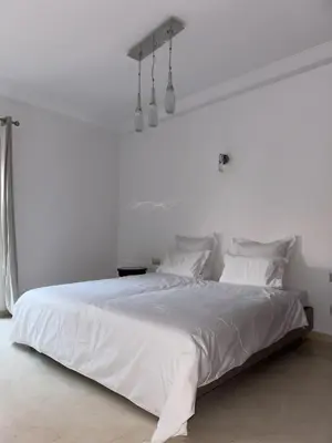 a white bed with white sheets and pillows at Luxury 2 bedroom apartment - Gueliz Plaza in Marrakech