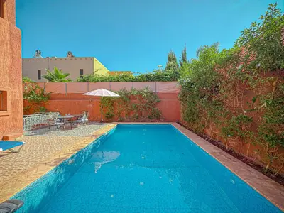 a swimming pool in a backyard with a brick wall at Villa Andalus - Piscine privée & Suite Parentale in Marrakech