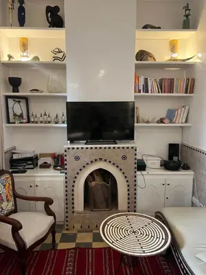 a living room with a fireplace with a tv at Riad Marhaba Kasbah in Marrakech