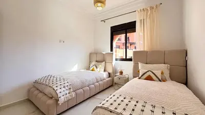 a bedroom with two beds and a window at Appart cosy & chic premium Village, 5 piscines in Marrakech
