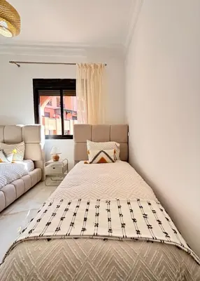 a bedroom with a bed and a couch at Appart cosy & chic premium Village, 5 piscines in Marrakech