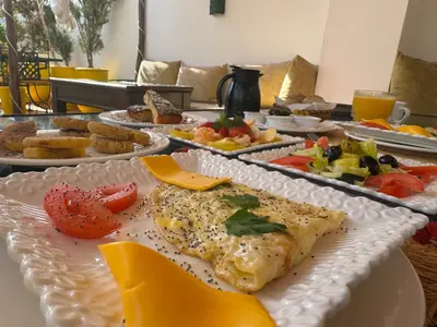 a table with a plate of food on it at Riad Iklil Hce in Marrakech