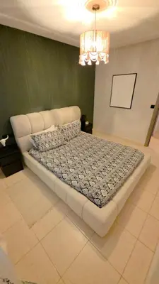 a large bed in a room with a chandelier at Cocon Zen in Marrakech