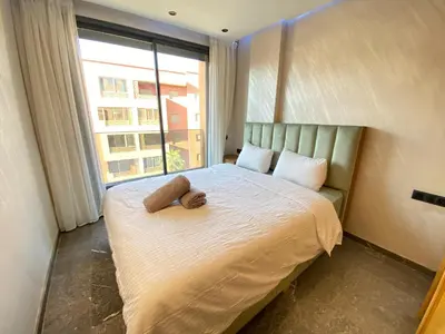 a bedroom with a large bed with a large window at Chic garden & grand balcon in Marrakech