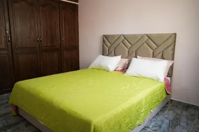 a bedroom with a green bed with two pillows at Appartement Moderne a Marrakech - 2 Chambres, Salon et Cuisine Equipee in Marrakech