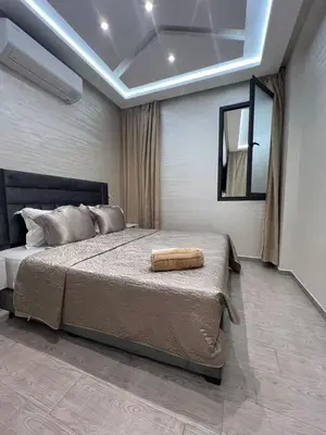 a bedroom with a large bed and a mirror at Des appartements conçus pour votre confort in Marrakech