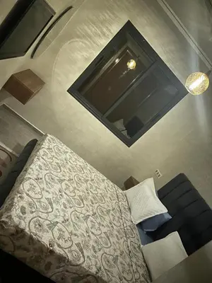 a bedroom with a bed and a couch at Residence miraj 24 in Marrakech