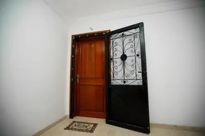 a wooden door with a wrought iron gate at Bel Appartement 2 Chambres Confort et Emplacement Idéal in Marrakech