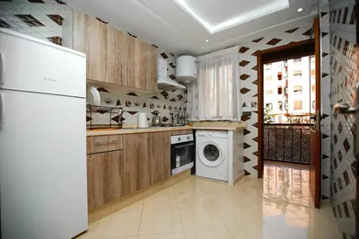 a kitchen with a refrigerator and a washing machine at Bel Appartement 2 Chambres Confort et Emplacement Idéal in Marrakech