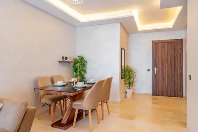a dining room with a wooden table and chairs at AFCON Stay Gueliz 2BR & Pool, Parking & Wi-Fi in Marrakech