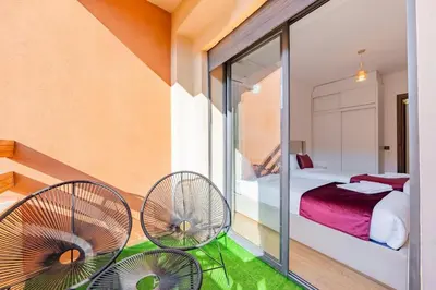 a balcony with two chairs and a bedroom at AFCON Stay Gueliz 2BR & Pool, Parking & Wi-Fi in Marrakech