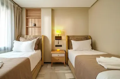 a hotel room with two beds and a night stand at Gueliz Prime 2BR Perfect Central Stay in Marrakech in Marrakech