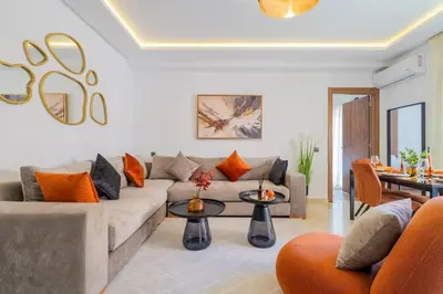 a living room with a couch and a table at Cozy Gueliz Apartment , Access to Pool , Central Location in Marrakech