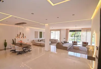 a living room with a table and a dining room at Villa Marrakech - Argan Golf - Swimming Pool in Marrakech