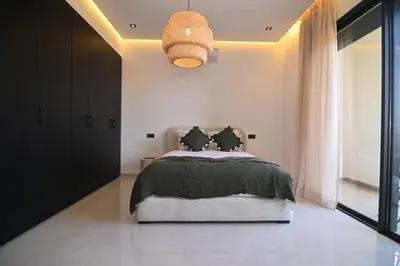 a bedroom with a bed and a pendant light at Villa Marrakech - Argan Golf - Swimming Pool in Marrakech