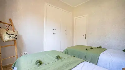 two beds in a room with two green sheets at Appartement cosy, calme, détente, piscines, jardins in Marrakech