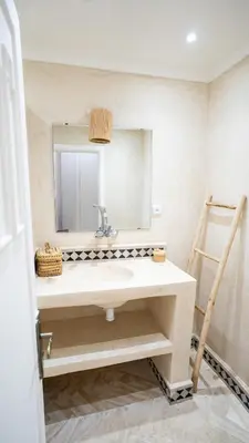 a bathroom with a sink and a mirror at Appartement cosy, calme, détente, piscines, jardins in Marrakech
