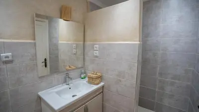 a bathroom with a sink and a mirror at Appartement cosy, calme, détente, piscines, jardins in Marrakech