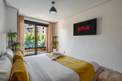 a bedroom with a bed and a tv on the wall at Modern 1BR , Balcony & WiFi & 2min Eden in Marrakech